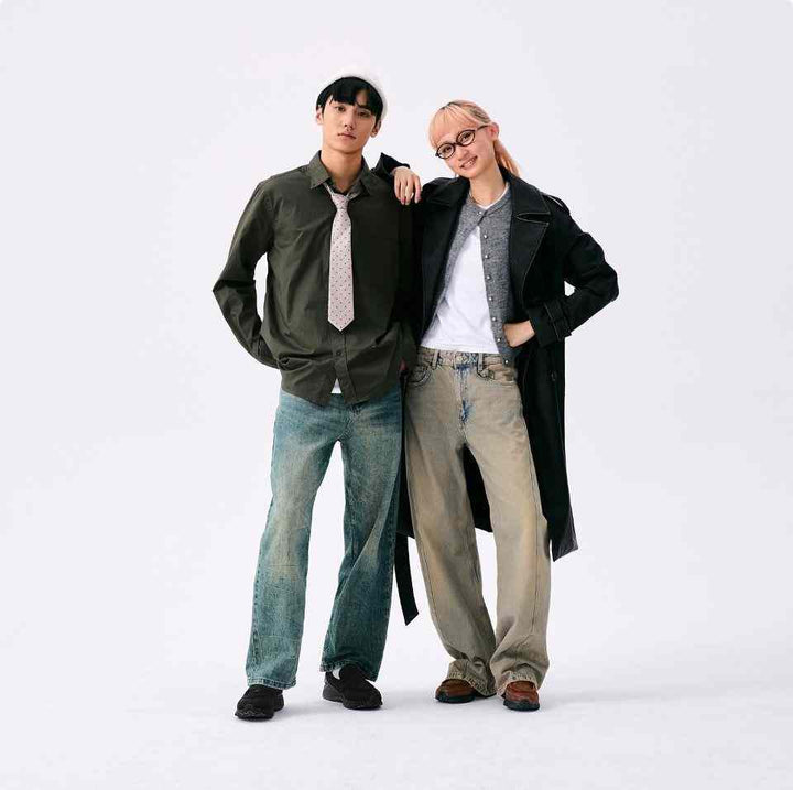 Two young adults wearing casual outfits featuring New Balance 1906 brown sneakers with mesh and leather details, standing against a white background.