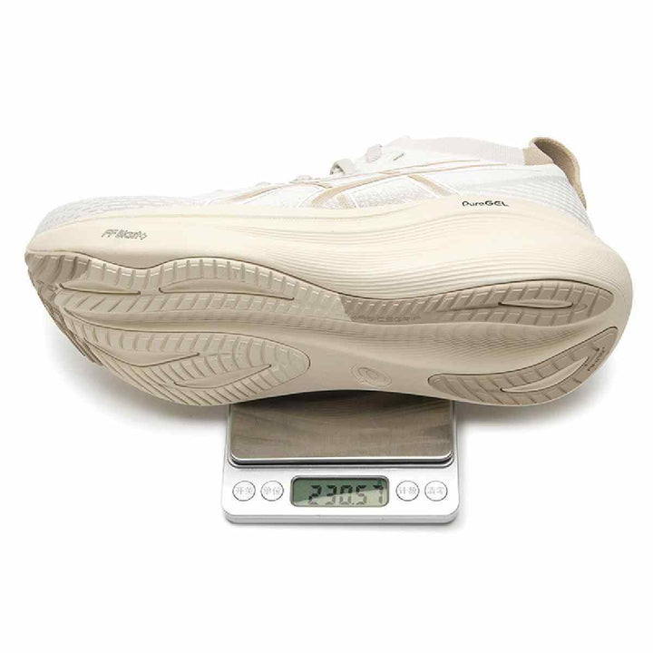 ASICS Gel-Nimbus 27 with beige design on a scale showing weight, highlighting advanced cushioning and lightweight technology.