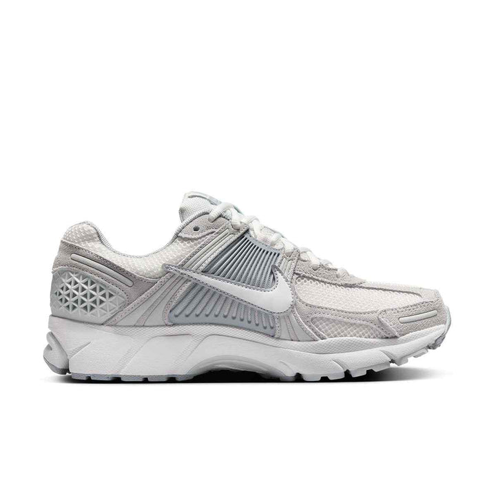 Nike VOMERO 5 breathable women's sneakers in light grey, showcasing shock-absorbing sole and ergonomic design.