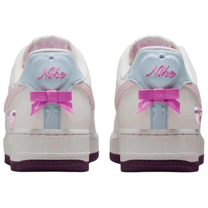 حذاء Nike Air Force 1 أبيض مزين بفيونكة وقلب وردي.