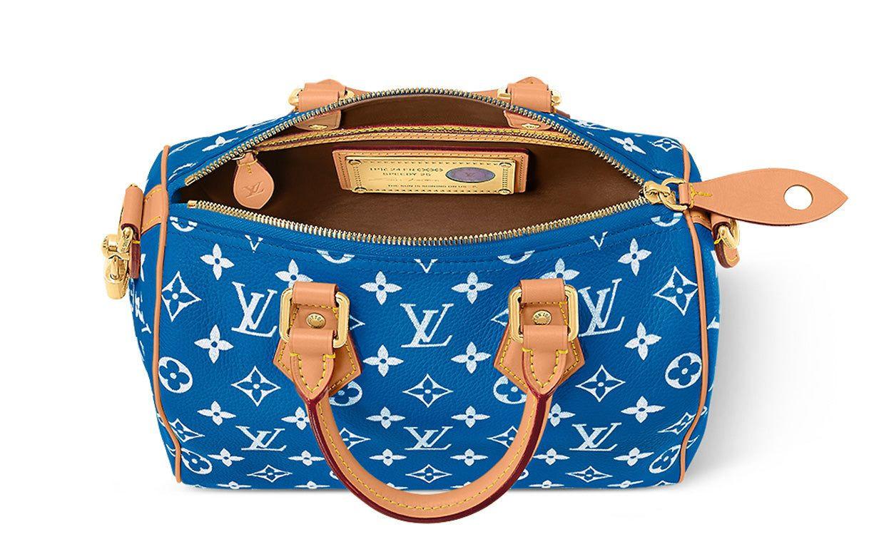 حقيبة Speedy 25 جلد باللون الأزرق ونقشة Monogram بيضاء.