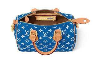 حقيبة Speedy 25 جلد باللون الأزرق ونقشة Monogram بيضاء.