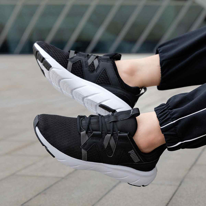 Puma unisex black sports shoes with grey stripes and white sole.