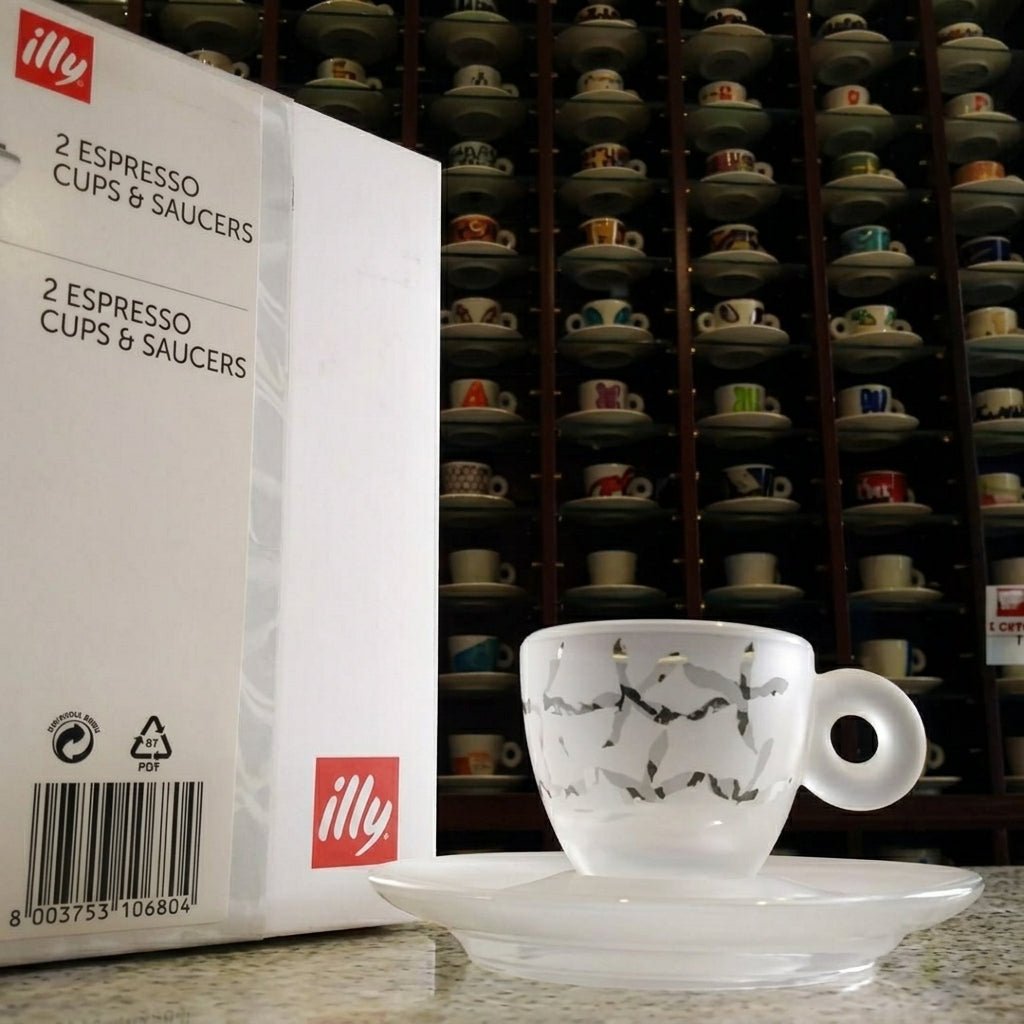 علبة هدية illy مطبوعة بجانب فنجان اسبريسو مزخرف مع صحنه