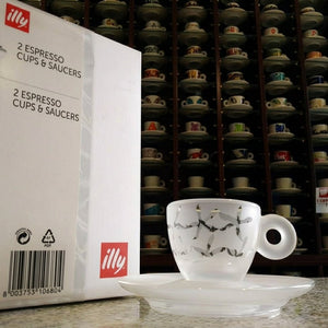علبة هدية illy مطبوعة بجانب فنجان اسبريسو مزخرف مع صحنه