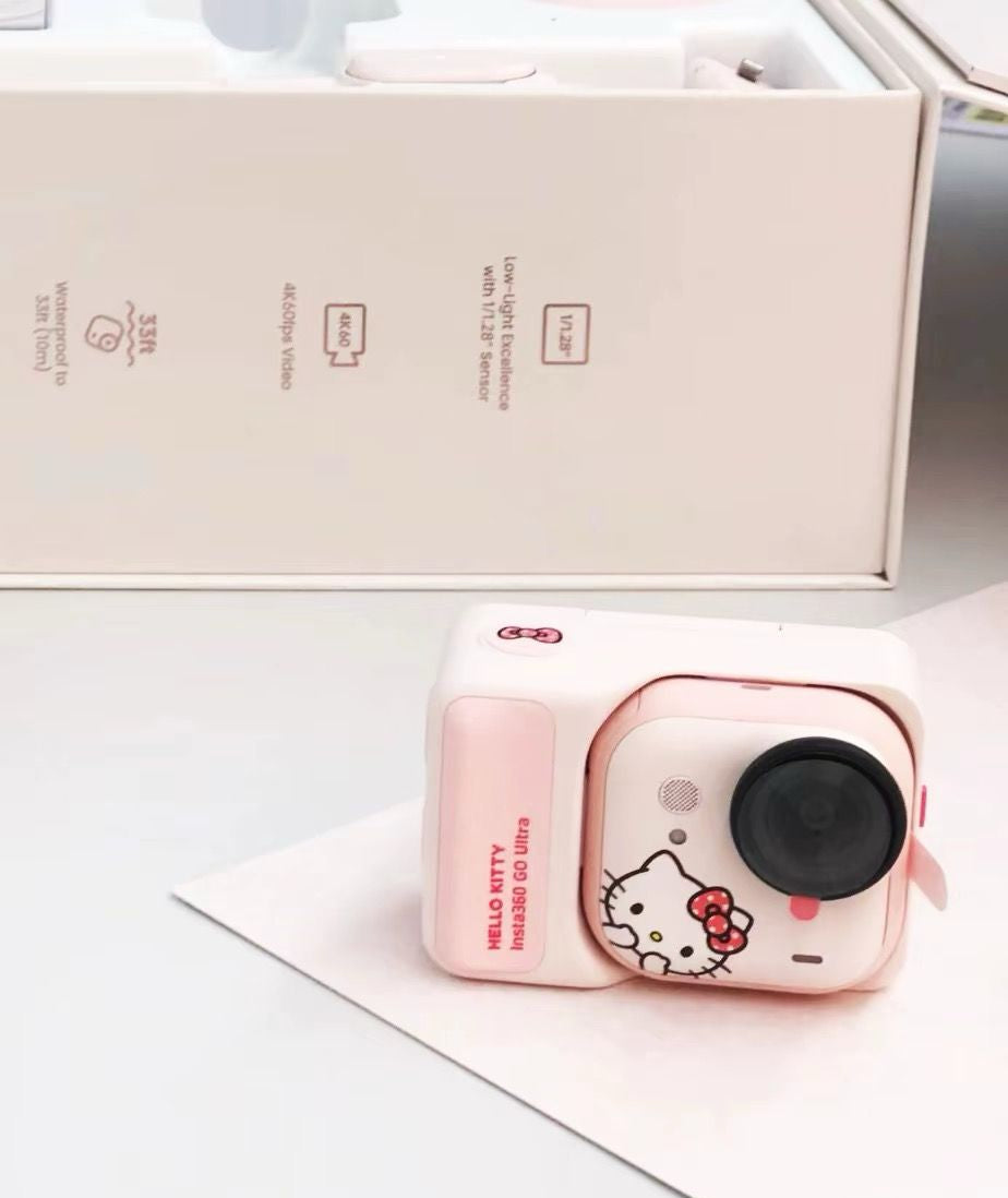 A close-up of the pink Hello Kitty Insta360 GO Ultra action camera placed next to its original white premium packaging box showing key technical specifications.