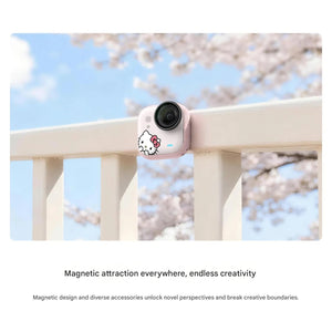 The pink Hello Kitty Insta360 GO Ultra camera mounted magnetically on a white outdoor railing under a clear blue sky.