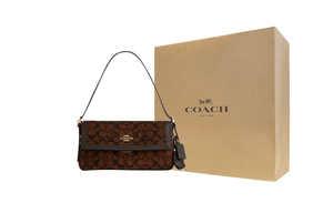 حقيبة كتف COACH بنقشة Signature المميزة باللون البني.