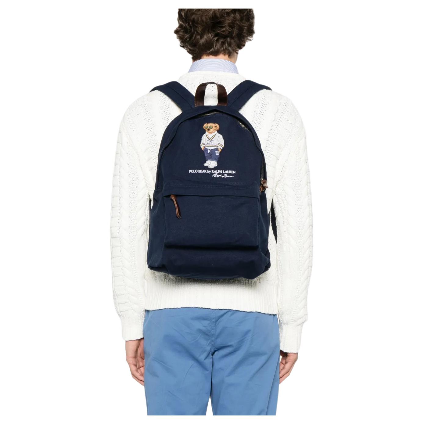 Back view of a man wearing an authentic Ralph Lauren Polo Bear navy backpack, perfect for back-to-school style and everyday use.

عرض من الخلف لرجل يرتدي حقيبة ظهر Ralph Lauren Polo Bear باللون الكحلي أصلية، مثالية لأسلوب العودة للمدرسة والاستخدام اليومي