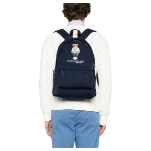Back view of a man wearing an authentic Ralph Lauren Polo Bear navy backpack, perfect for back-to-school style and everyday use.

عرض من الخلف لرجل يرتدي حقيبة ظهر Ralph Lauren Polo Bear باللون الكحلي أصلية، مثالية لأسلوب العودة للمدرسة والاستخدام اليومي