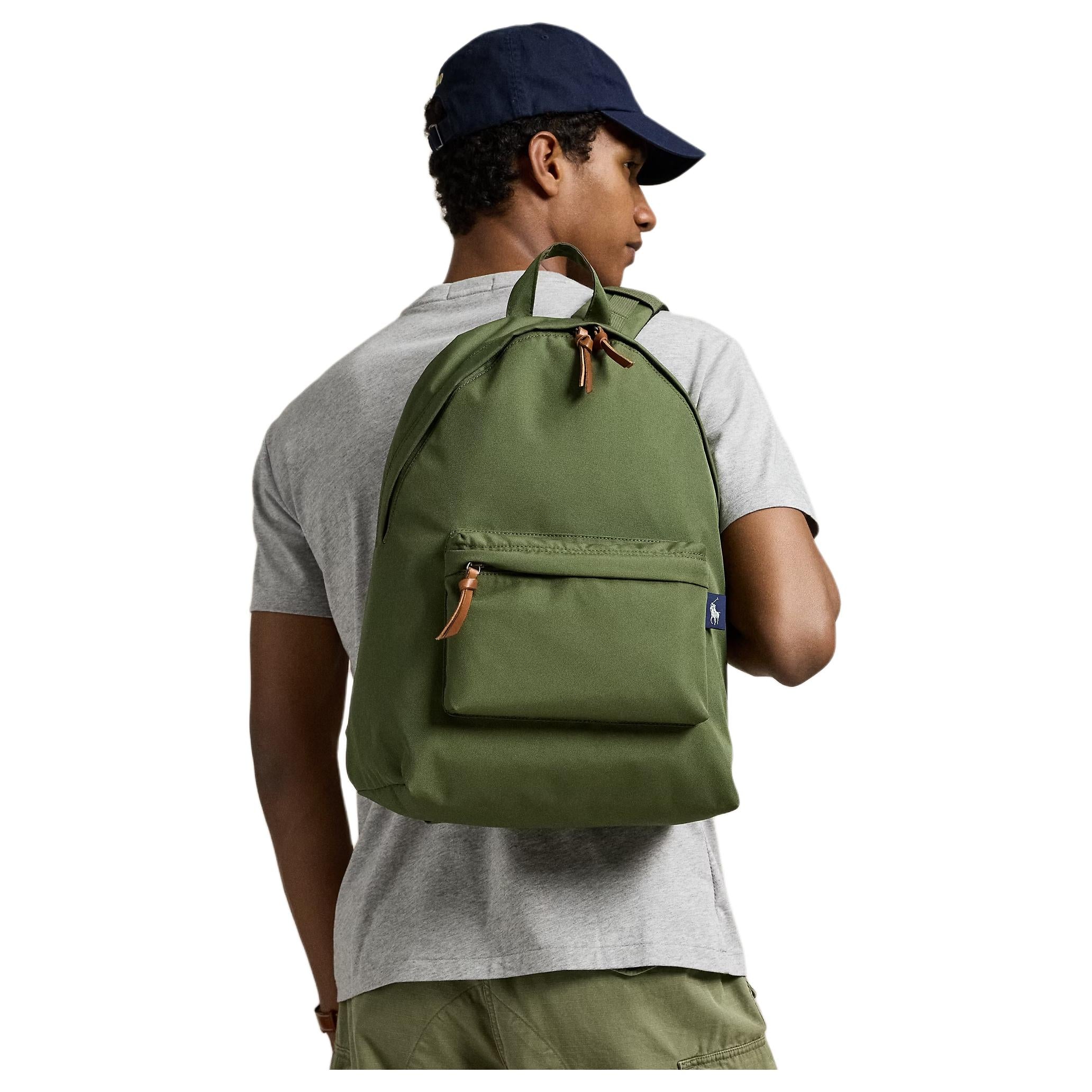 A man wearing an authentic Polo Ralph Lauren olive green backpack, perfect for back-to-school style and casual outfits.

رجل يرتدي حقيبة ظهر Polo Ralph Lauren أصلية باللون الأخضر الزيتوني، مثالية لأسلوب العودة للمدرسة والإطلالات اليومية.