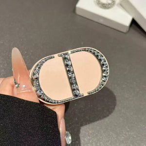 مسكة جوال قابلة للطي باللون الوردي الفاتح يمسكها يد