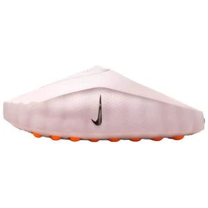 Side profile view of the Nike Mind 001 slip-on shoe in soft baby pink, showcasing its clean structural design, a black swoosh, and bright orange outsole pods.