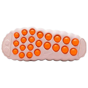 Bottom traction sole view of the Nike Mind 001 baby pink, featuring the textured orange grip pods designed for stability and comfort.