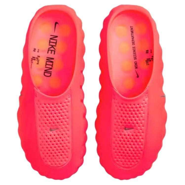 Top-down view of a pair of Nike Mind 001 neon orange shoes, showing the textured upper mesh and bright orange circular pods inside the footbed.