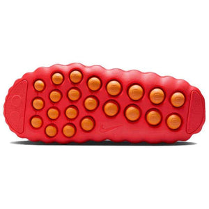 Bottom traction sole view of the Nike Mind 001 neon red, featuring the textured grip pods for stability and comfort.