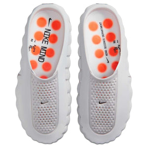Overhead top view of Nike Mind 001 shoes, revealing the interior sensory insoles equipped with bright orange pressure-point pods designed for mental focus and recovery.