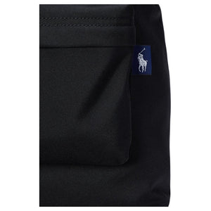 Detailed close-up of the woven navy blue pony logo tag on the side pocket of an authentic black Polo Ralph Lauren backpack.

لقطة قريبة مكبرة لعلامة شعار المهر المنسوجة باللون الكحلي على الجيب الجانبي لحقيبة ظهر Polo Ralph Lauren أصلية باللون الأسود.