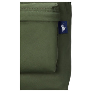 Detailed close-up of the woven navy blue pony logo tag on the side pocket of an authentic olive green Polo Ralph Lauren backpack.

لقطة قريبة مكبرة لعلامة شعار المهر المنسوجة باللون الكحلي على الجيب الجانبي لحقيبة ظهر Polo Ralph Lauren أصلية باللون الأخضر الزيتوني.