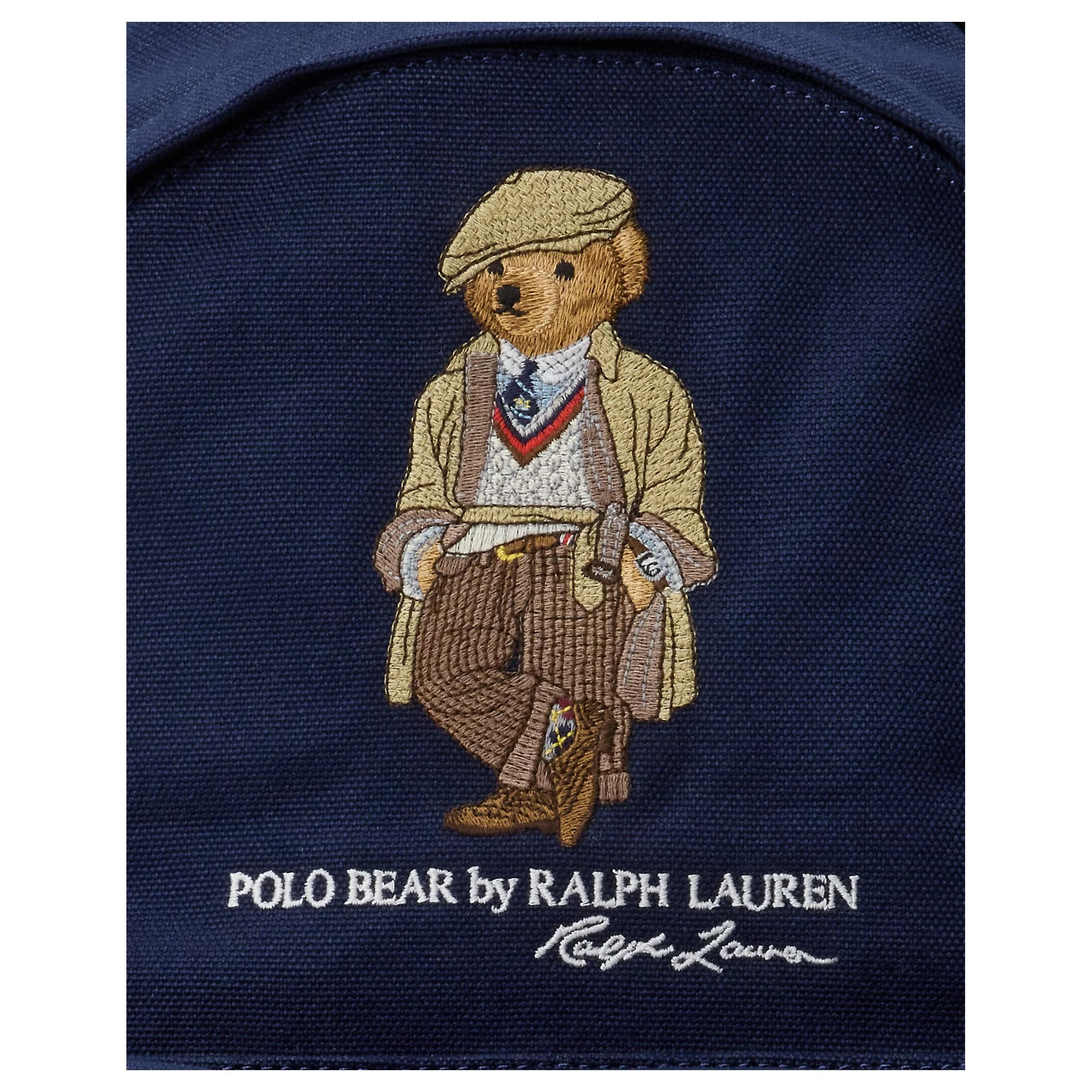 Detailed close-up of the signature embroidered Polo Bear and printed Ralph Lauren logo on an authentic navy blue backpack.

لقطة قريبة مكبرة لتطريز دب بولو الشهير وشعار رالف لورين المطبوع على حقيبة ظهر كحلي أصلية.