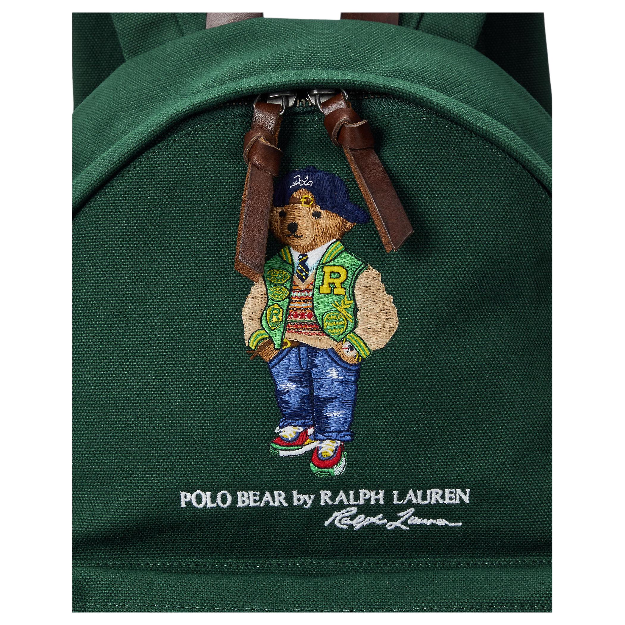 Detailed close-up of the signature embroidered Polo Bear wearing a varsity jacket on an authentic green Ralph Lauren backpack with brown leather zipper straps.

لقطة قريبة مكبرة لتطريز دب بولو الشهير بوهج سترة الستريت وير على حقيبة ظهر رالف لورين أصلية باللون الأخضر مع أشرطة سحاب جلدية بنية.