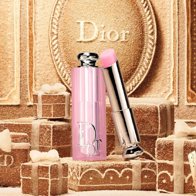 عطر ديور الوردي وبلسم الشفاه الفضي على خلفية ذهبية بيضاوية