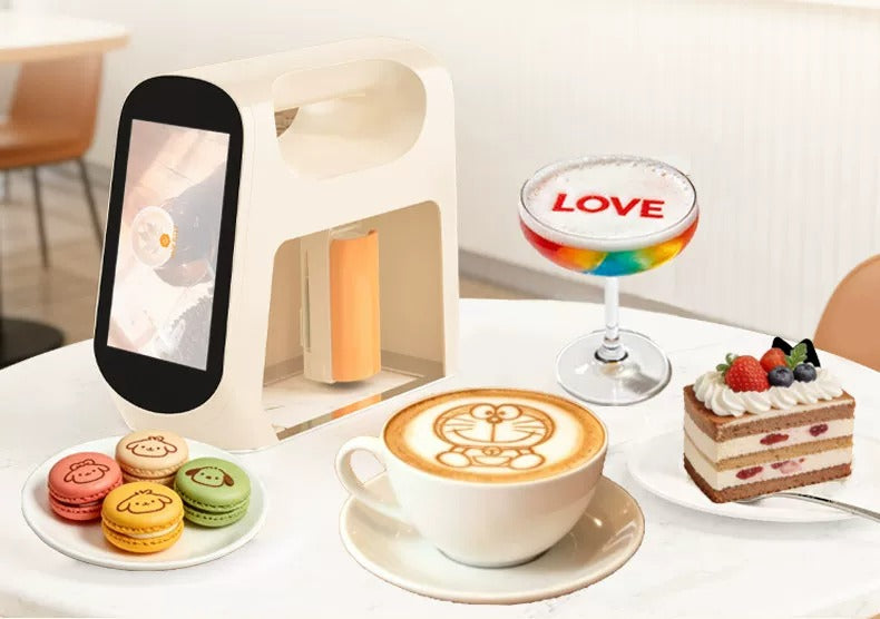 طابعة EVEBOT Smart مع فنجان قهوة وحلويات وماكارون على الطاولة