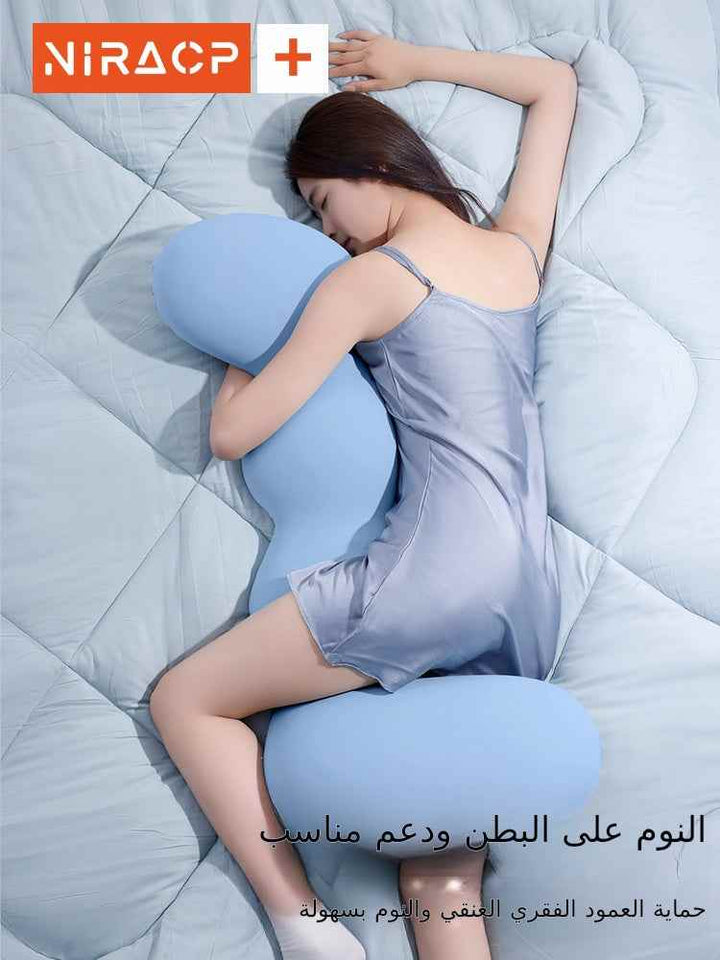 Pregnant woman using ergonomic large pillow on bed for side sleeping.