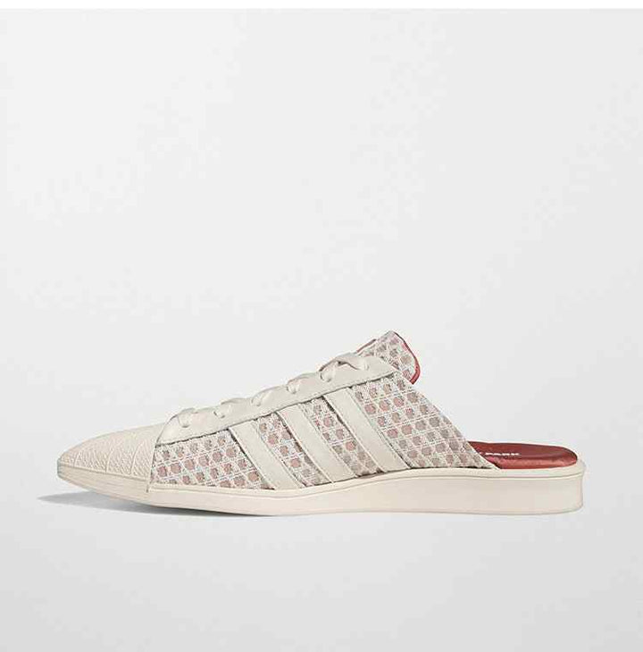 Adidas حذاء Ivy Park Mule نسائي بتصميم مفتوح الخلف وجريء مع أنف مدبب، طبعات هندسية، ولمسات جلدية كريمية.