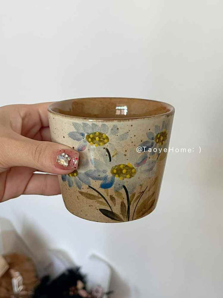 أكواب فخارية يدوية بطابع أزهار ريفي مزينة برسومات زهور نابضة بالحياة.
