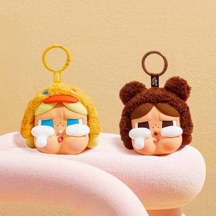 Cute Crybaby figurines with large teardrop expressions wearing animal hats, yellow duck and brown bear designs with keychain rings.