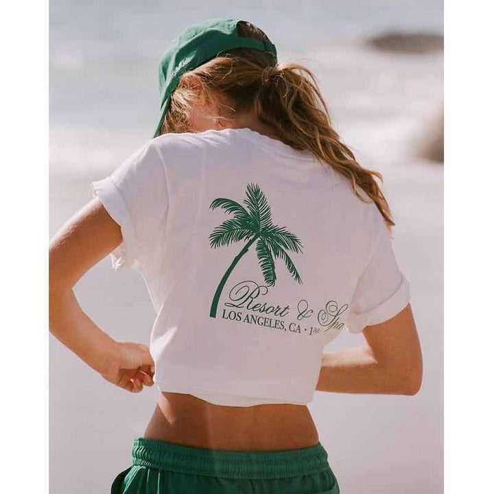 تيشيرت قطني أبيض بطباعة نخلة خضراء وعبارة Resort & Spa لوس أنجلوس تصميم صيفي مريح وخفيف