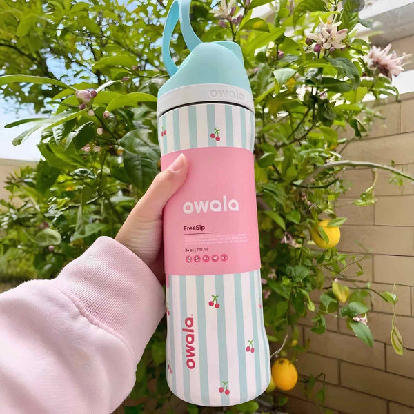 Owala FreeSip stylish stainless steel water bottle with dual drinking spout and leak-proof design in pink and striped pattern