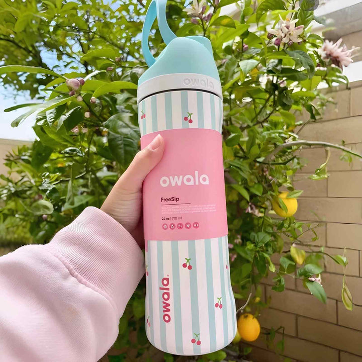 Owala FreeSip stylish stainless steel water bottle with dual drinking spout and leak-proof design in pink and striped pattern