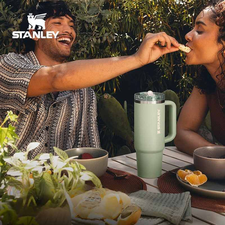 ستانليStanley insulated stainless steel travel mug with handle in green, perfect for hot and cold drinks, featuring leak-proof lid and modern design.