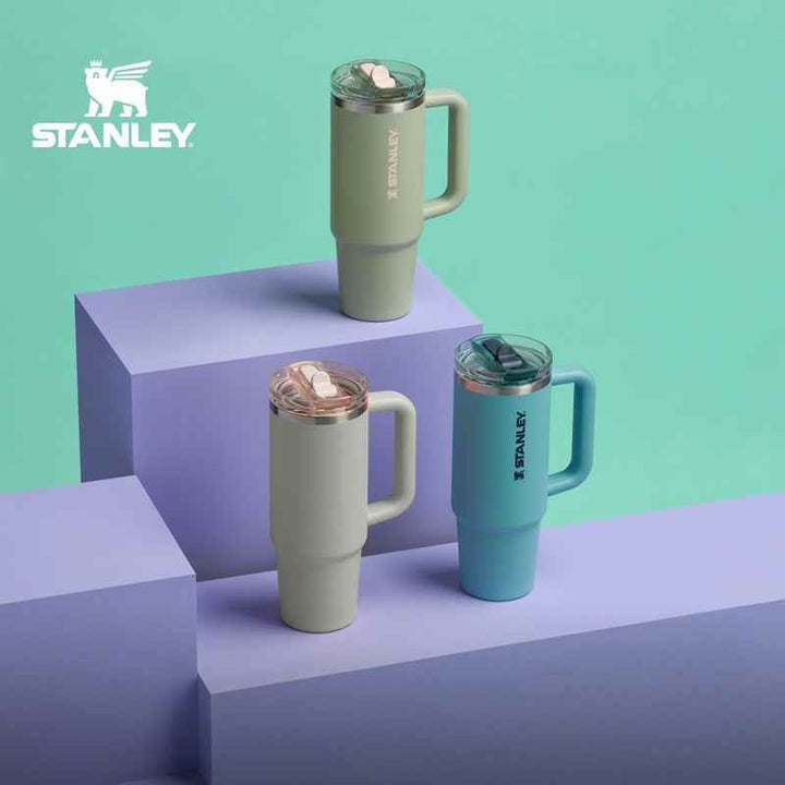 Stanley insulated stainless steel mugs set with handles in green, gray, and blue for hot and cold drinks.
