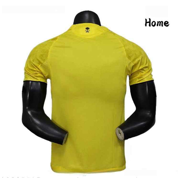 Yellow NASSR Riyadh 1955 football jersey with black details and breathable fabric, player edition home kit.