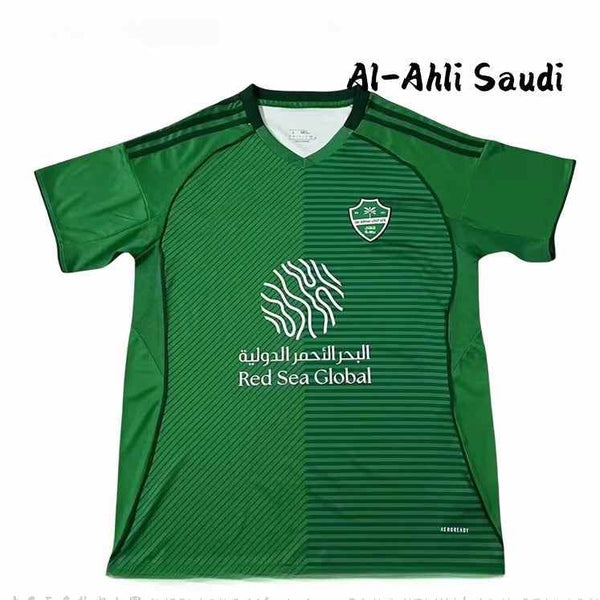 Green Al Ahli 25/26 football jersey with diagonal stripes, club crest, and Red Sea Global sponsor logo in white.