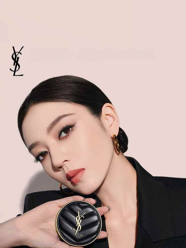 YSL Cushion Foundation luxury compact held by elegant woman with flawless glowing skin and minimal makeup on beige background