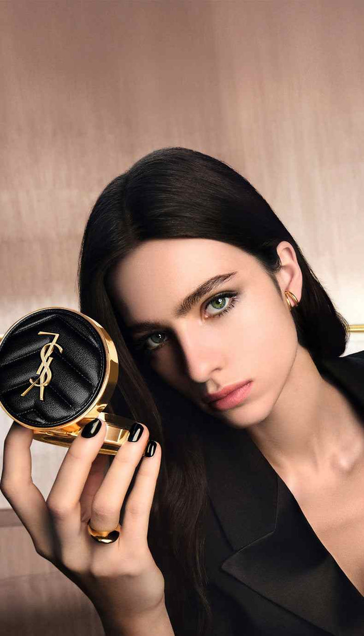 Elegant woman holding YSL Cushion Foundation compact showcasing luxury makeup product with natural radiant finish