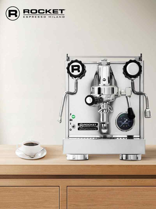Rocket Appartamento Italian espresso machine with heat exchanger and professional E61 group head on wooden counter with coffee cup