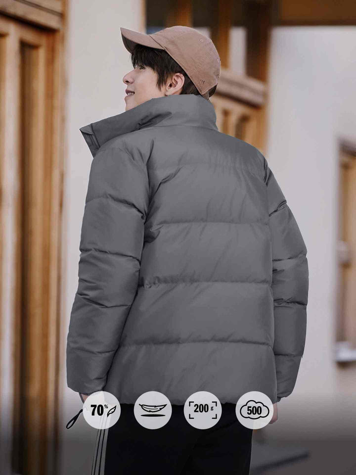 رجل يرتدي Adidas جاكيت داون دافئ 500 Puff رمادي مع ياقة عالية وخياطة أفقية