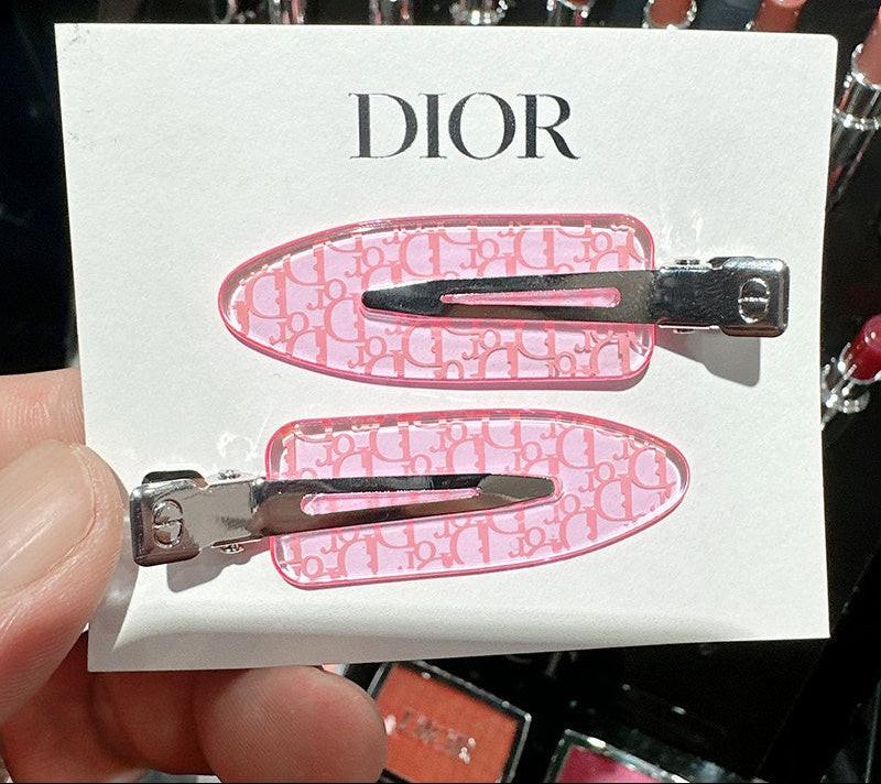 مشبك شعر Dior بتصميم بنقشة Oblique باللون الوردي.