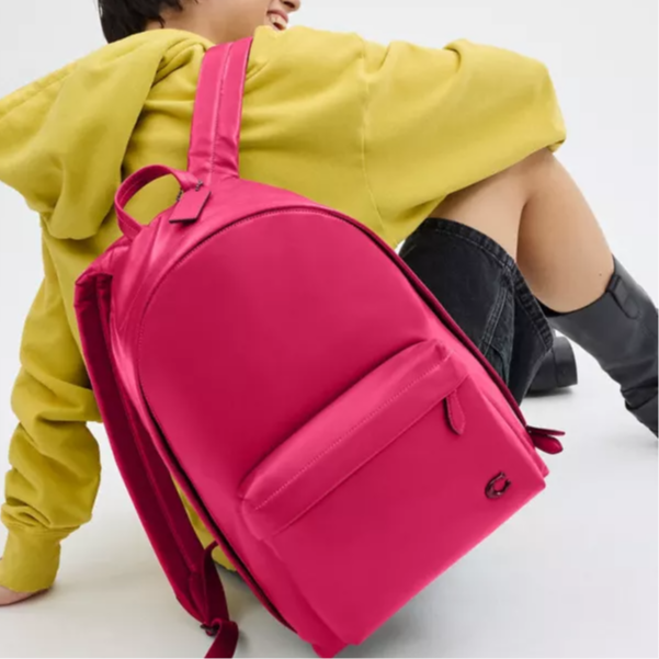 Lifestyle view of a woman styled with an authentic Coach Westway 32 fuchsia leather backpack, perfect for back-to-school fashion.

عرض نمط حياة لامرأة ترتدي حقيبة ظهر كوتش ويست واي 32 أصلية جلد باللون الفوشيا، مثالية لمظهر العودة للمدرسة العصري.